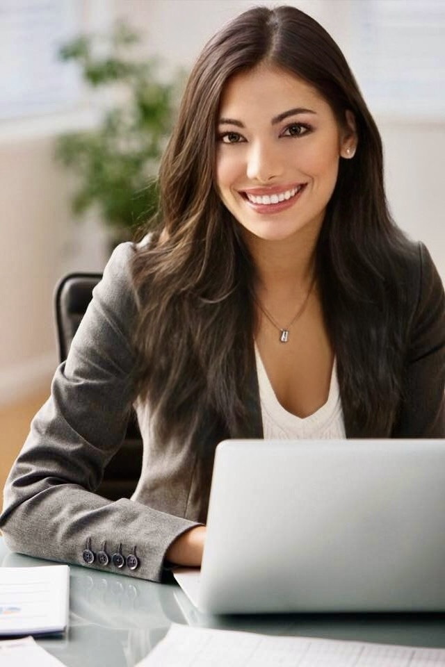 Waleska Latorre from Mastering Dating smiling and sitting at her laptop